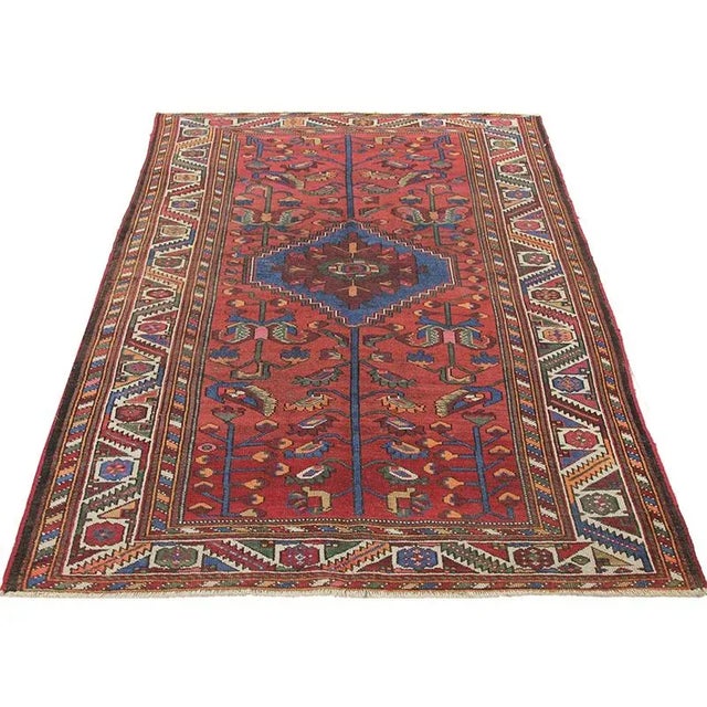 Antique handwoven Persian Malayer rug with a rust-colored background and ivory-colored border, accented with shades of...