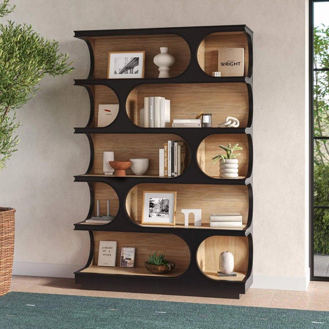 Finished in Batavia Black with a Sandbar finish interior, this bookcase showcases rhythmic, crescent-shaped oval cut-outs...