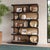 Finished in Batavia Black with a Sandbar finish interior, this bookcase showcases rhythmic, crescent-shaped oval cut-outs...