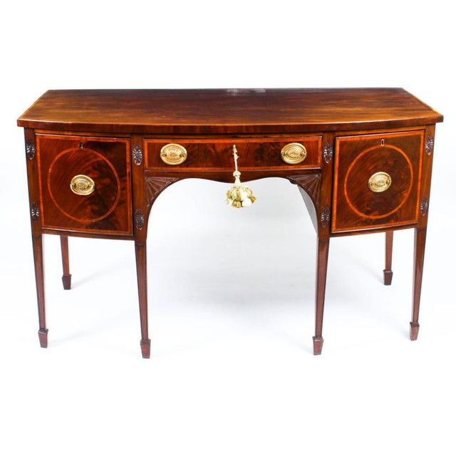 This is a superb antique George III inlaid flame mahogany bowfront sideboard, circa 1780 in date. The top is banded in...