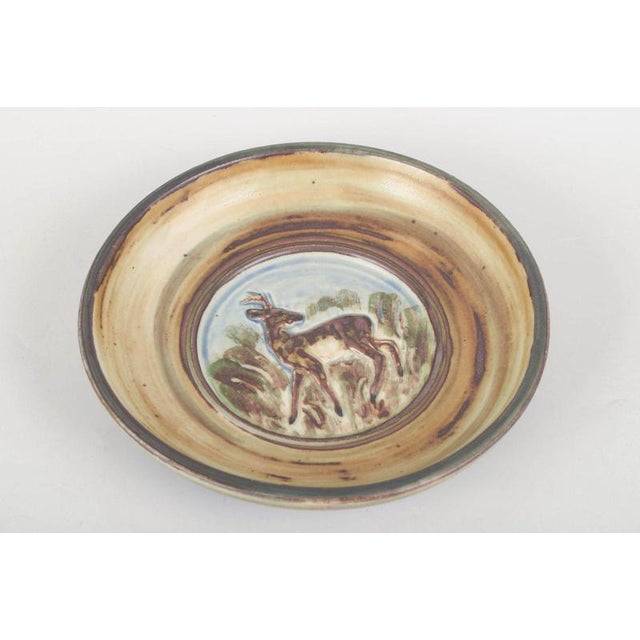 Knud Kyhn for Royal Copenhagen, stoneware dish. Round stoneware dish, model 21214, decorated in relief with a deer in a...