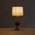 A 1970s Italian table lamp, reminiscent of designs by Pierre Casenove. Stacked blown glass spheres in rich oxblood red...