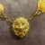 This necklace from the 1960s is a piece of costume jewelry with a bold, gold-tone design. It features a chain of round...