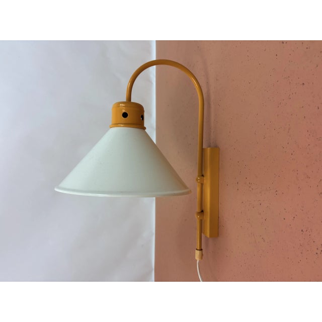 Arc Wall Lamp 1970s Funky arc wall lamp from the 70s. The lamp has a yellow metal frame with a white metal shade....