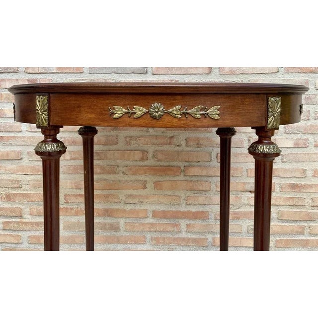 French side table, with oak and wood top, from the mid-20th century. This antique table from France is oval shaped at the...