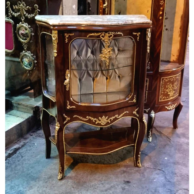 Elegant and richly detailed, this French Louis XV-style display cabinet is crafted from solid wood and designed to...