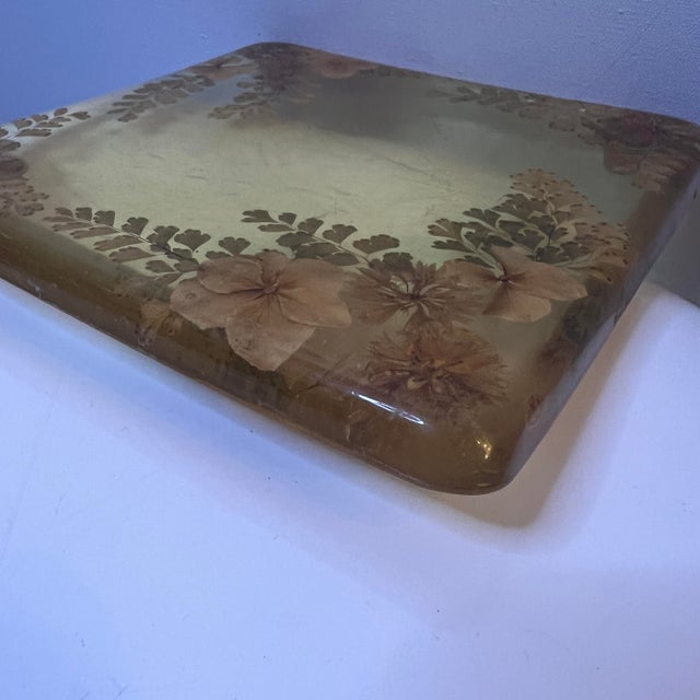 Vintage pressed-flower lucite trivet or decorative tray with embedded botanical inclusions in warm amber resin. Square...