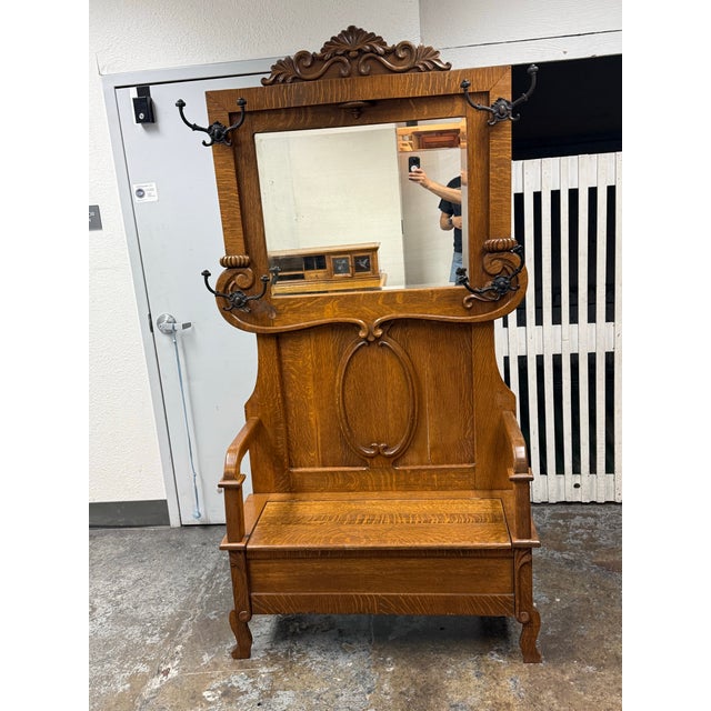 Design Plus Gallery presents an Antique Oak Hall Tree/Entry Bench. This antique oak hall tree has a paneled back, lift-...