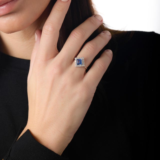 This refined Edwardian ring is a remarkable testament to early 20th-century elegance, centered around a captivating square...