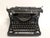 A 1938 Model 6 Underwood typewriter. The vintage typewriter has a black finish with closed sides. The typewriter has some...