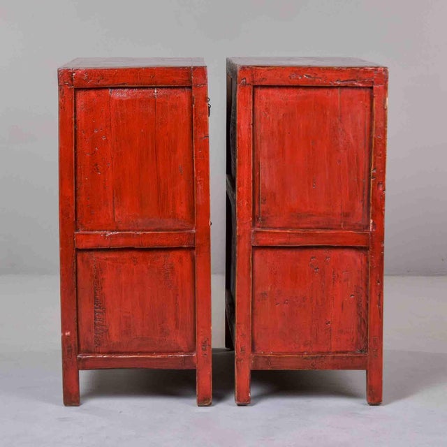 Each cabinet is constructed in softwood and finished throughout in a red-painted ground with green and gilt-outlined panel...