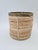 A stylish container made of natural rattan with a brass rim, designed in the aesthetic of 1960s–70s Italian design. The...