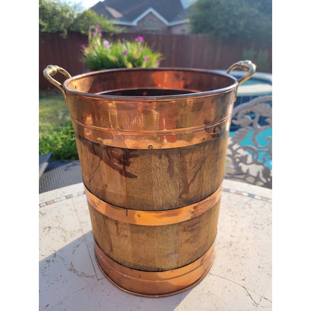 A handsome mid‑century oak firewood bucket featuring copper metal bands and solid brass swing handles. The piece has a...