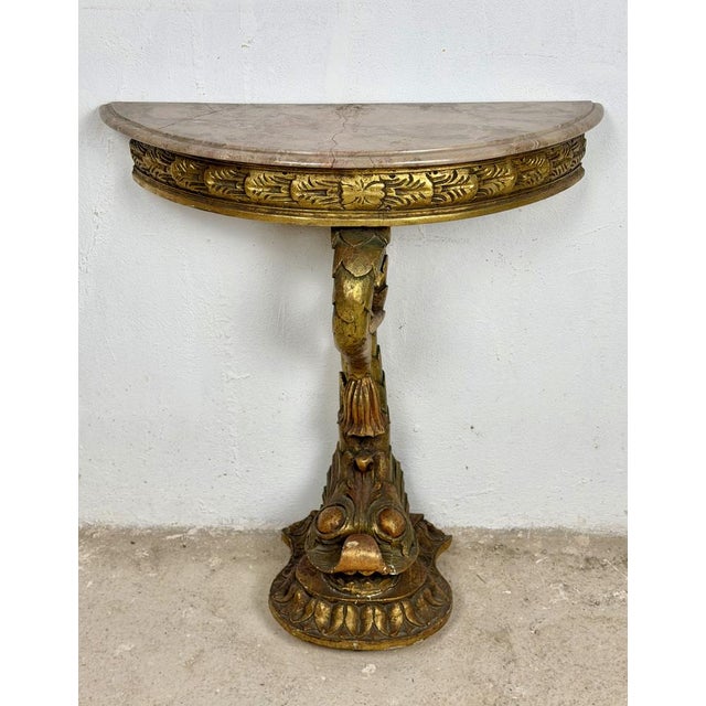 Elegant Italian demi-lune table crafted in carved and polychromed wood, featuring a shaped marble top and an impressive...