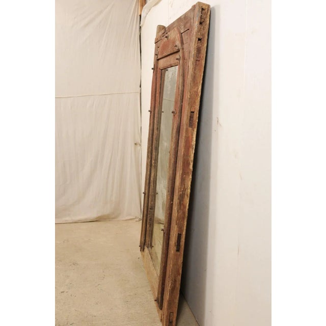 A one of a kind custom mirror using an 18th century Spanish door frame as surround. This antique wooden door frame from...