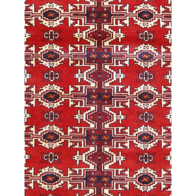 This vintage Balouch design rug, crafted from wool, showcases a rich red color that brings warmth and character to any...