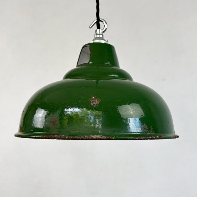 An industrial pendant light by maxlume, with a pressed steel shade in green vitreous enamel outside and white enamel...