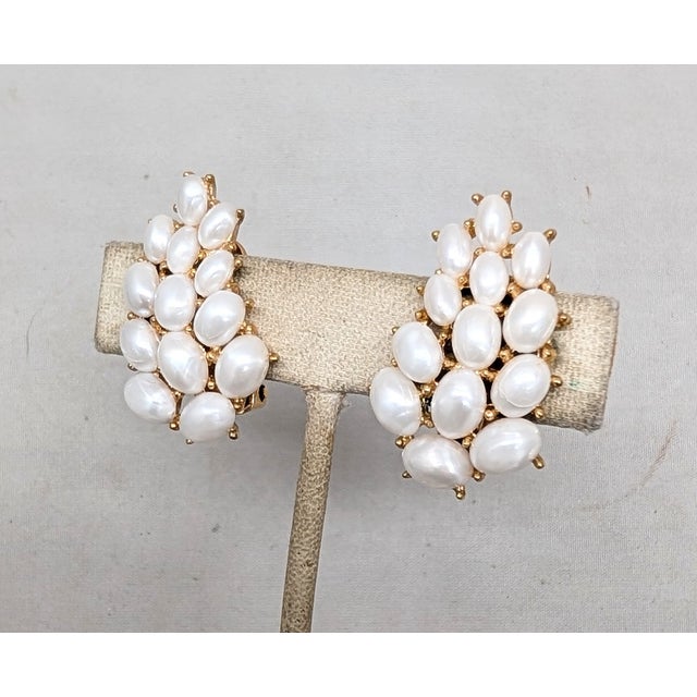 1958 goldtone oval faux-pearls with uneven sheen clip earrings. Marked crown "TRIFARI©" on the clips. Measure: 1 1/4...