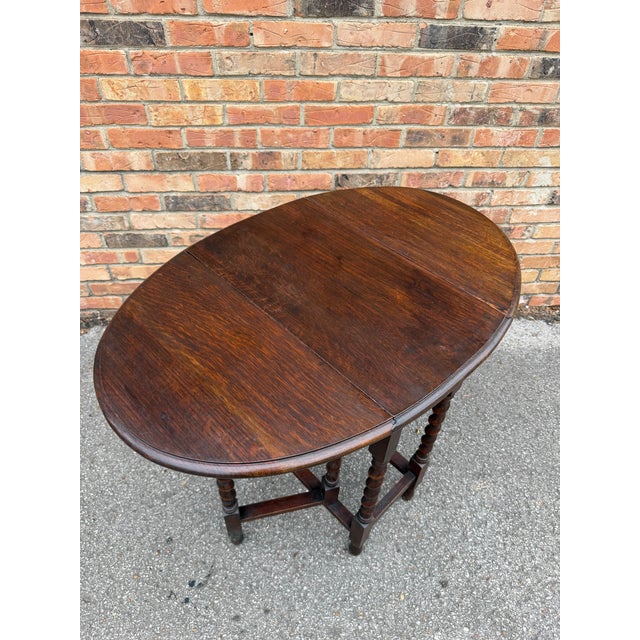 This finely crafted antique gateleg table is constructed of solid English oak with a rich, deep patina developed over...