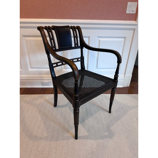 Elegant neoclassical–style armchair featuring a finely crafted painted wood frame in a rich black finish with subtle warm...