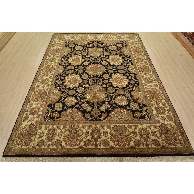 A traditional Agra rug is hand-knotted with fine wool on a cotton foundation. This rug features a botanical design set...