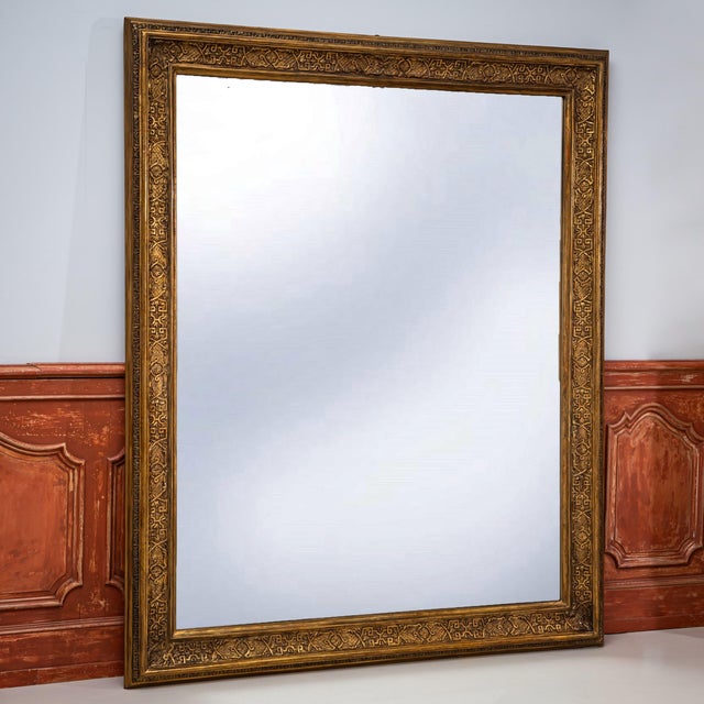 Very large wall mirror with a tall rectangular gilt stucco frame. The frame features crisp molded profiles and delicate...