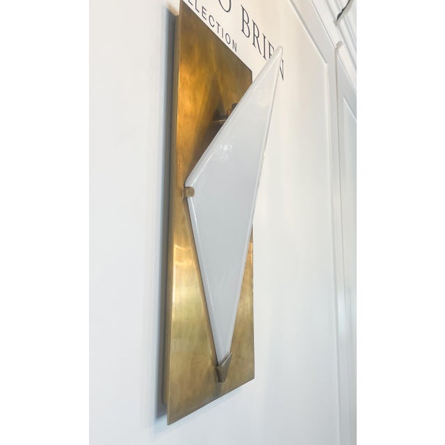 This stunning mid-century modern sconce is the discontinued Forma Sconce by Visual Comfort. It features a stunning brass...