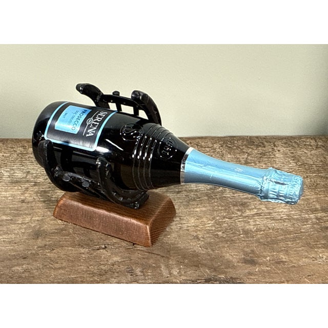 This wine bottle holder is crafted from actual horseshoes and horseshoe nails arranged in a cradle formation. The metal...