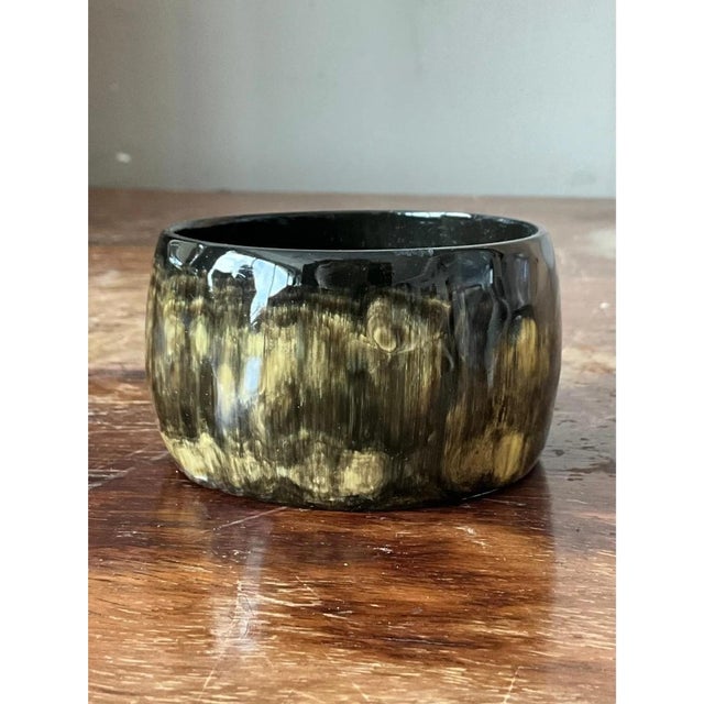 This vintage bangle is handcrafted from durable resin, designed to mimic the rich texture and natural tones of genuine...