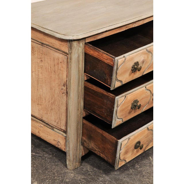 A French provincial Louis XV period carved and painted wood commode from the mid 18th century. This antique chest from...