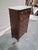 A French walnut semainier chest of drawers featuring a molded white marble top above six graduated drawers fitted with...