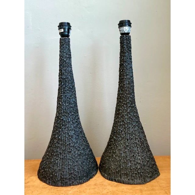Defined by soaring conical silhouettes and dramatic tactile depth, this pair of vintage table lamps features an elongated...