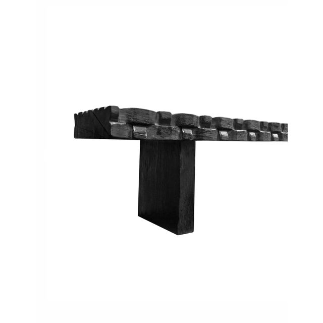 A sculptural hand-carved mango wood bench. To achieve is rich black pigment the bench was burnt three times and then...