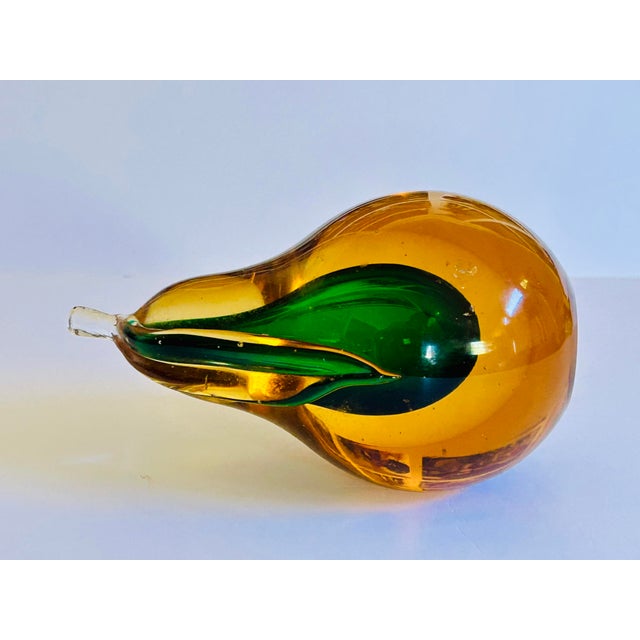 Large hand-blown Murano glass pear features a green "sommerso" core suspended within a clear amber body and transparent...