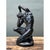 This expressionist sculpture captures a seated male figure in a deeply contorted, emotionally charged pose, one arm raised...