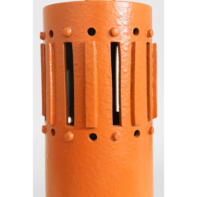 Vintage sculptural ceramic table lamp with a cylindrical form, architectural cutouts, and a textured burnt orange glaze....