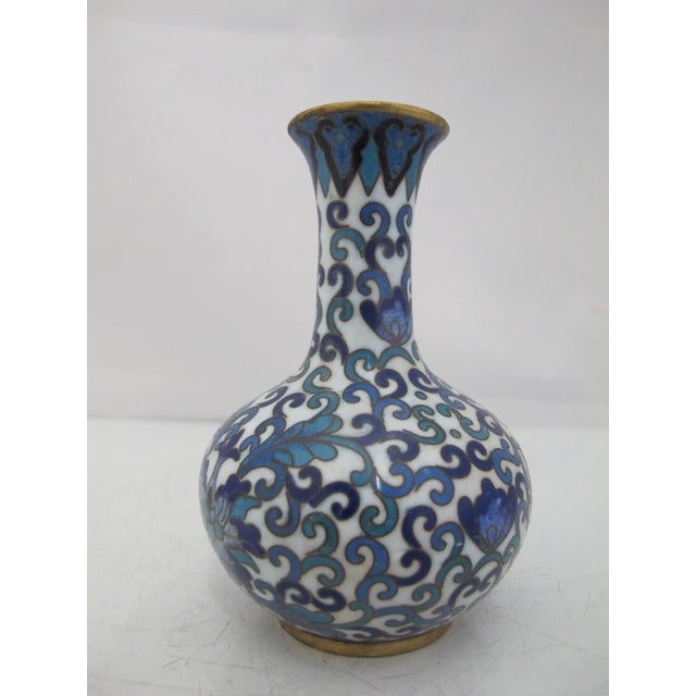 Small Chinese Cloisonne vase. Brass with white enamel background showing vibrant cobalt blue and turquoise flowers and a...