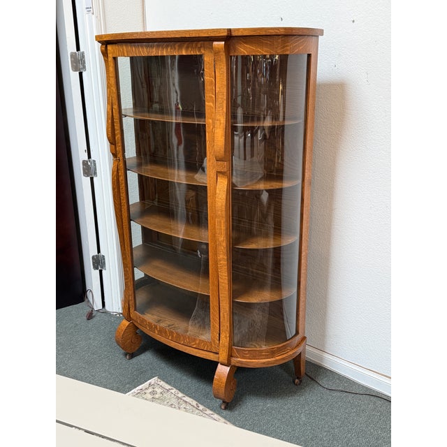 Design Plus Gallery presents an Antique Age Curio Cabinet. The curio has a central glass paneled door with two curved...