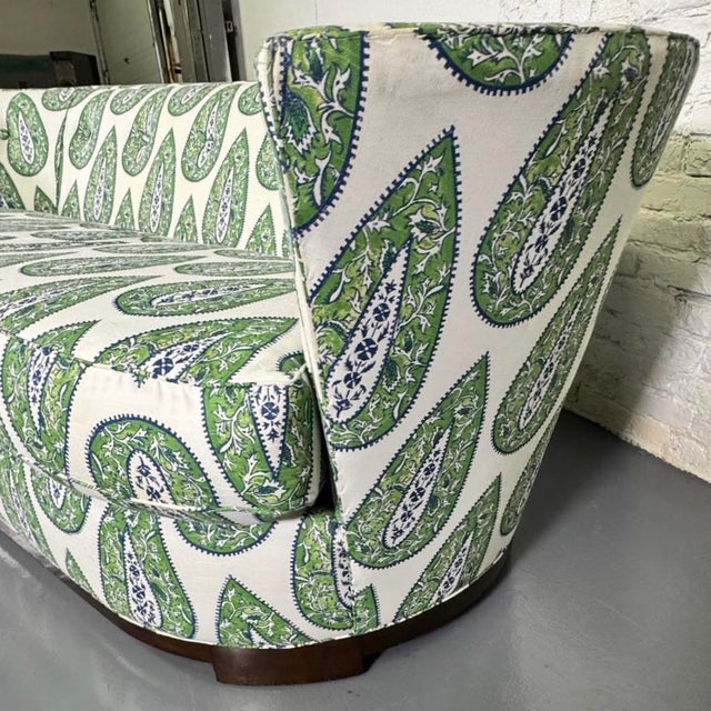 Mid- century modern sofa reupholstered in cotton paisley fabric from Mindy Kelly. Mahogany frame with exposed lower trim....