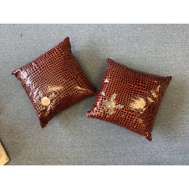 A pair of decorative brown faux crocodile pillows hand embellished with abalone shell and jeweled crabs by ANKASA. Taffeta...