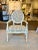Classic French style Avery arm chair with an antiqued cream frame, rossett medallions, and fluted legs, mid-century style...