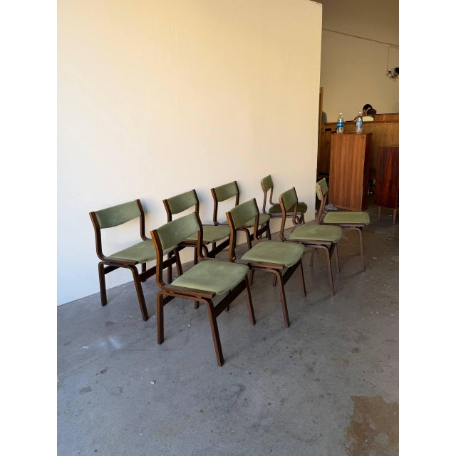 Beautiful set of eight Mid Century Modern Danish dining chairs featuring elegant wooden frames and green upholstered seats...