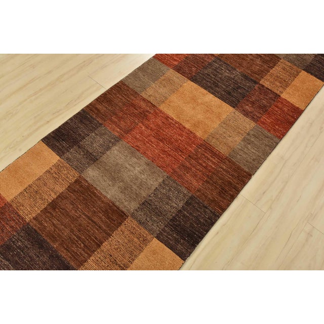 A contemporary Gabbeh runner hand-knotted with fine wool on a cotton foundation. This rug features geometric shapes in...