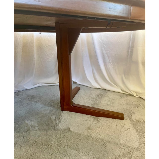 Professionally refinished Danish teak dining table stamped by Svend A.Madsen. Starts out as 52” round top with expandable...