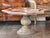 Octagonal low table with a stone top set over a central pedestal base. The top has a faceted octagonal outline with a...