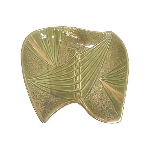 This is a gilded olive green ceramic ashtray in a boomerang shape. This Mid-Century bar accessory is so unique and a very...