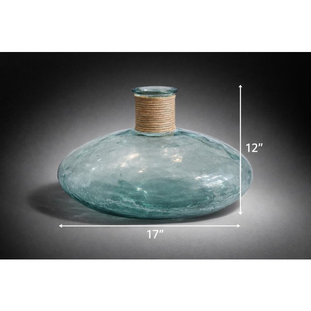 Mobile-Ready Blurb Large aqua recycled glass demijohn-style decorative vessel with a wide sculptural form and natural...
