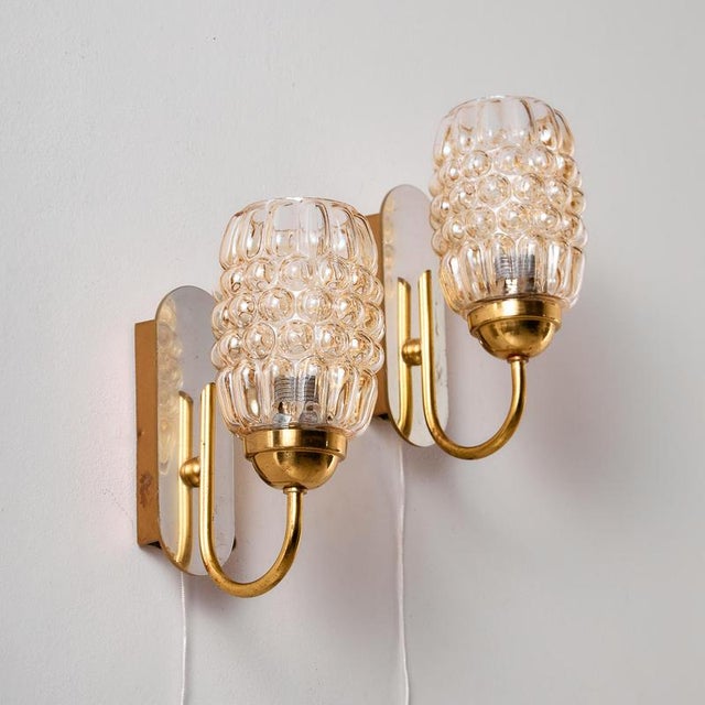 A pair of bubble glass wall lamps designed by Helena Tynell for Limburg in the 1960s. The lamps have organic shapes and...