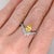 A yellow sapphire sits in a rich blue at the centre of this solid 14K white gold ring, surrounded by twenty-two earth-...