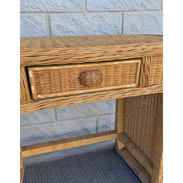 Vintage three-piece wicker vanity set, complete with an arched mirror and matching stool. The vanity features a woven...